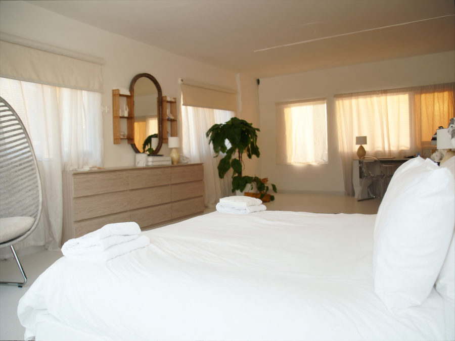 A vacation rental bedroom staged with fresh linens and folded towels