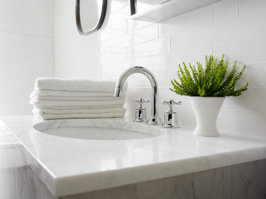 A sparkling clean bathroom vanity with rolled towels